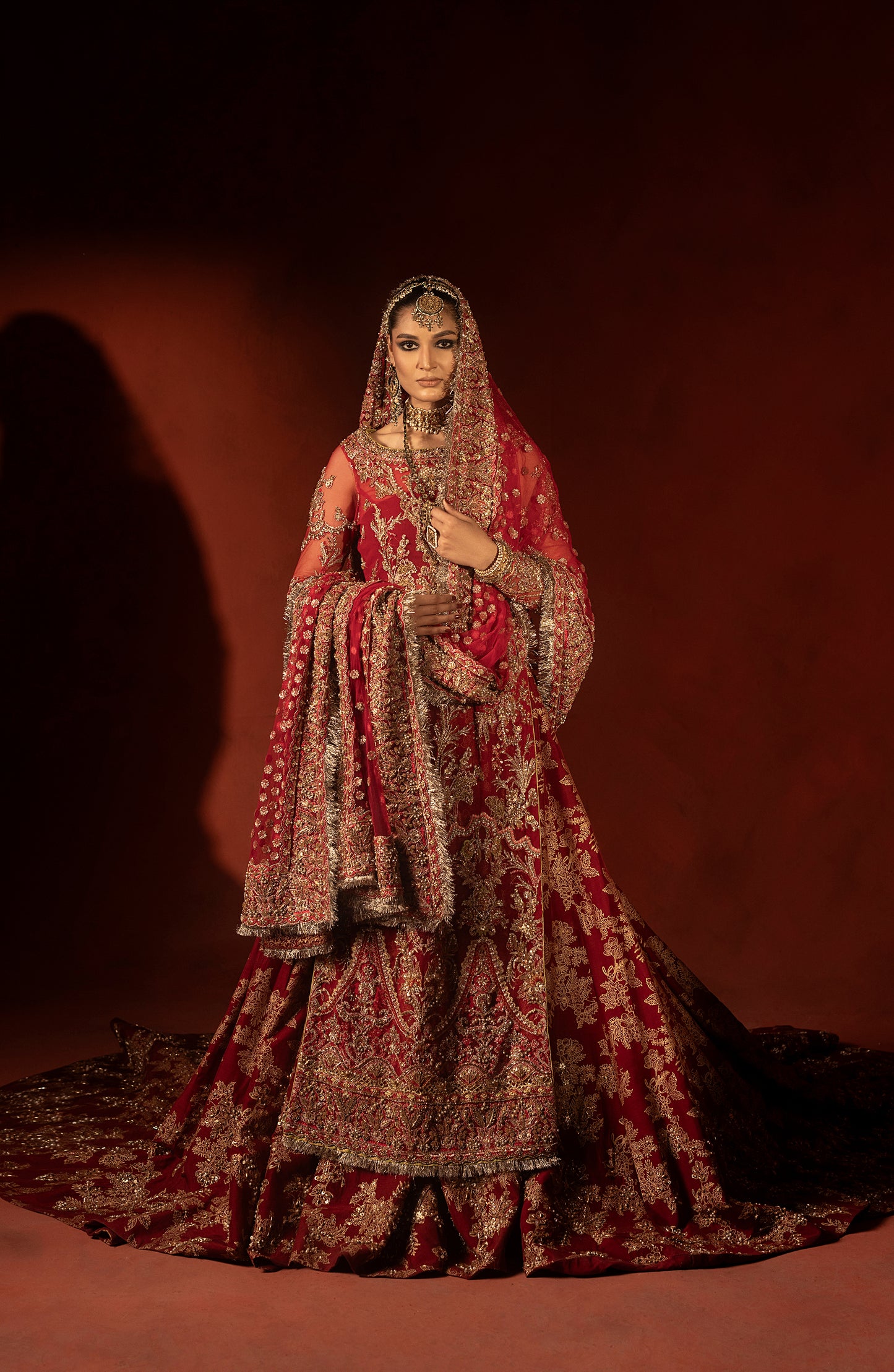 Closeup of raspberry red bridal lehenga fabric and detailing