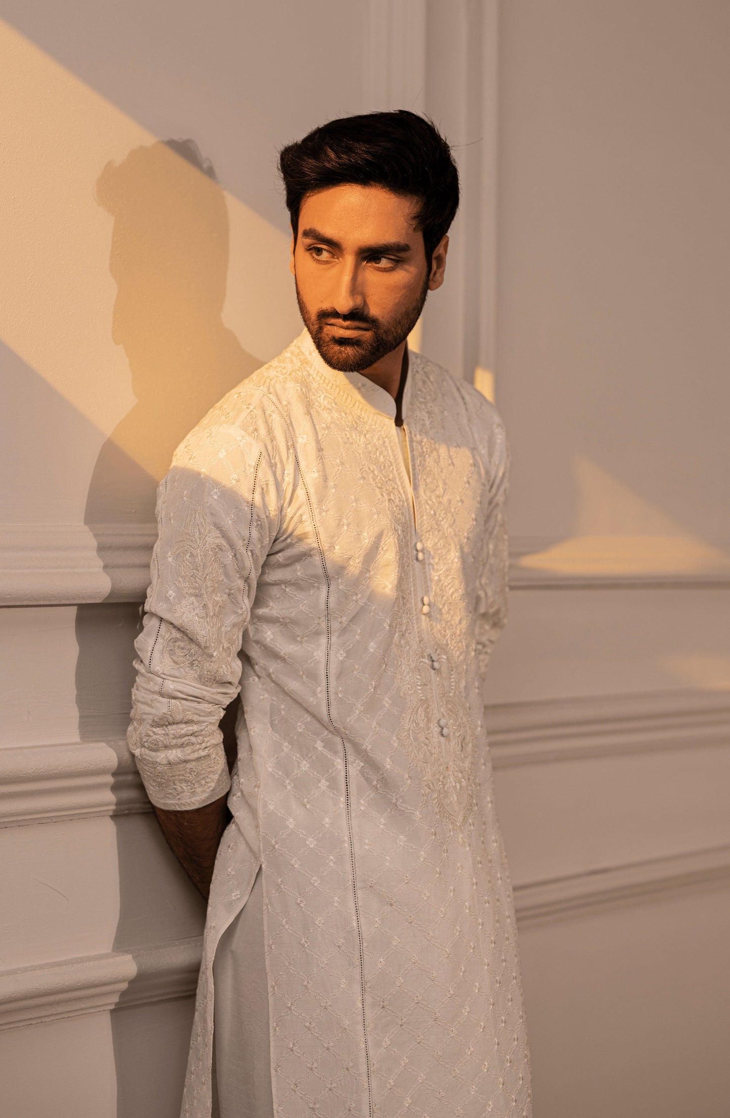 Shop luxury Pakistani kurta designs for men-Side profile of Classic White male kurta shalwar highlighting fine fit.