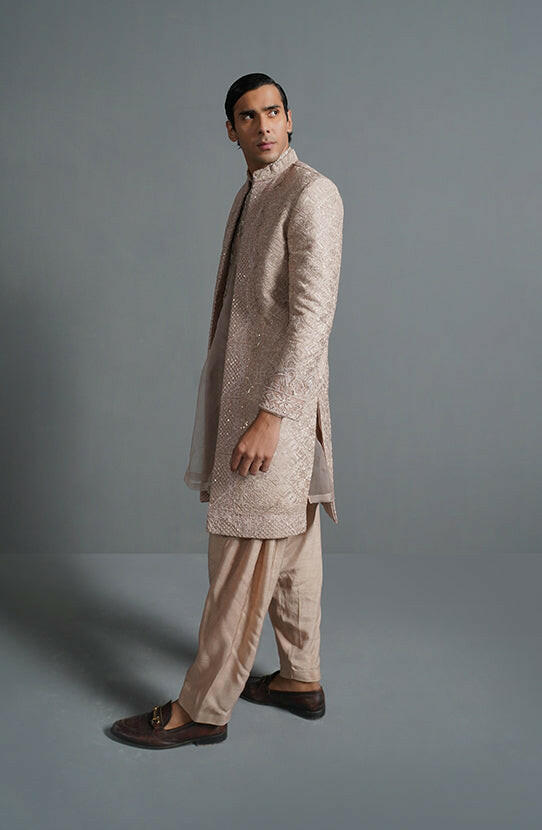 HSY Designer sherwani online USA-Side profile of primrose pink sherwani highlighting tailored fit and embroidery.