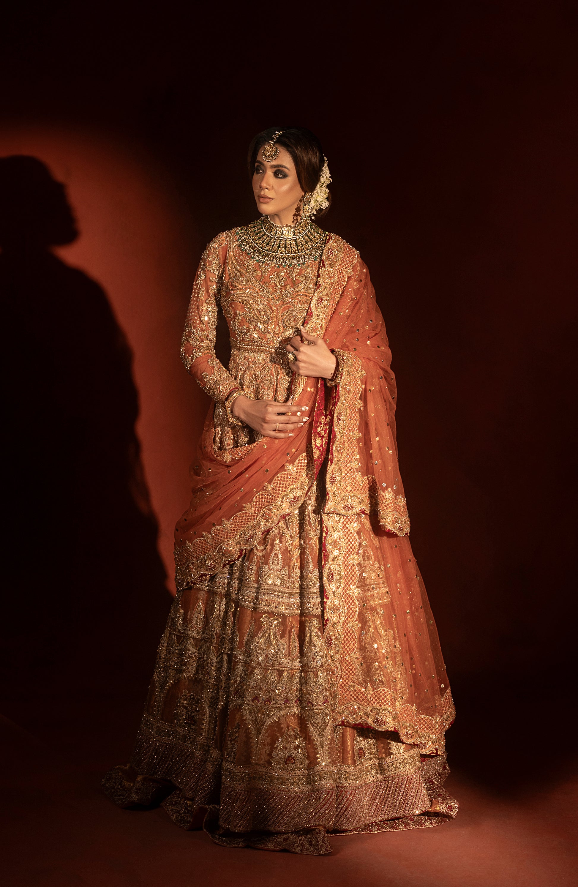 Back design of rust orange bridal pishwas and jamawar lehenga