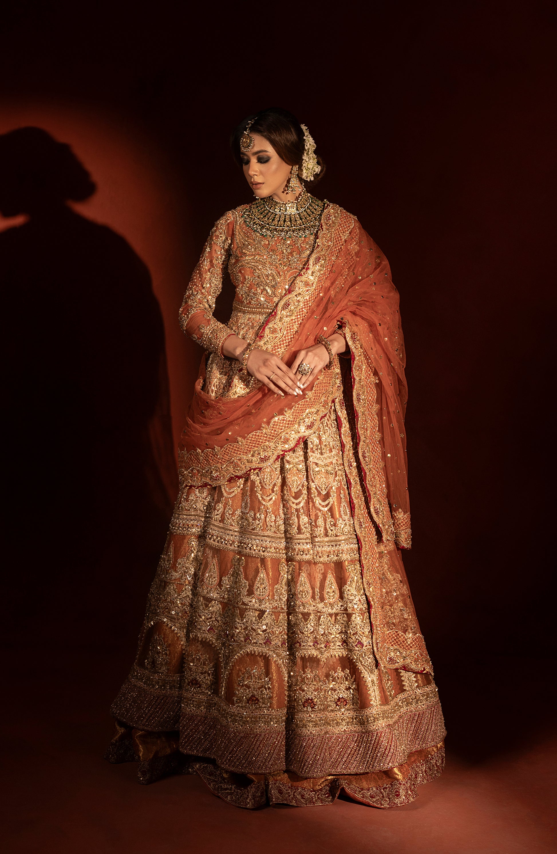Full view of rust orange pishwas and jamawar lehenga set