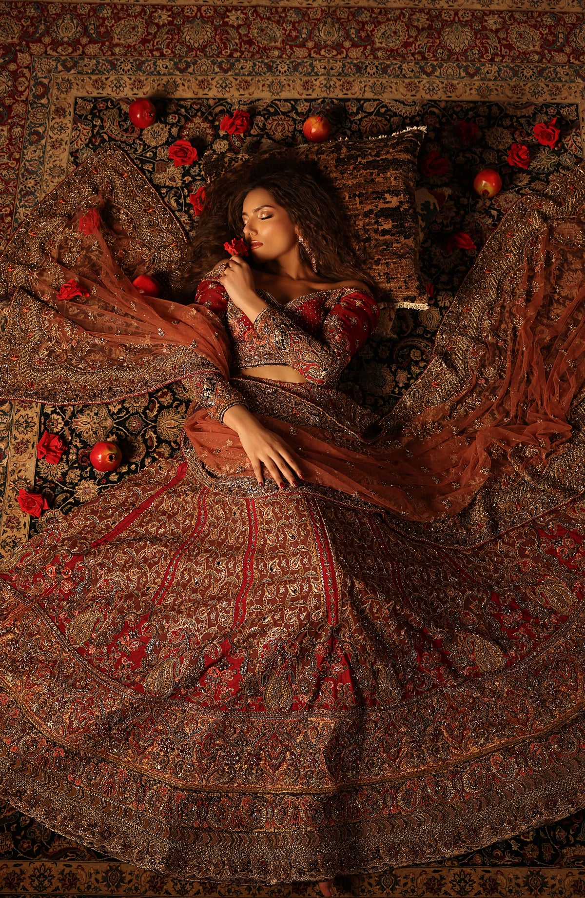Woman in traditional attire lying on a patterned carpet with flowers