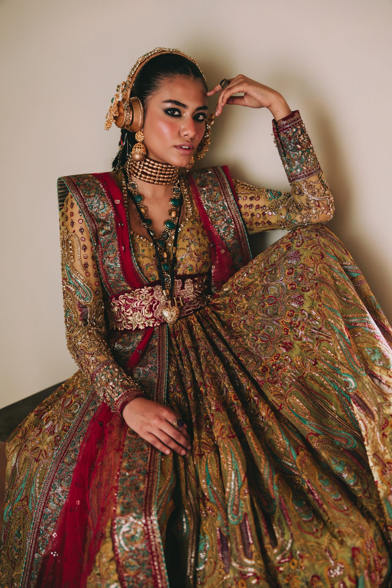 Woman in an ornate traditional outfit with intricate patterns and jewelry.