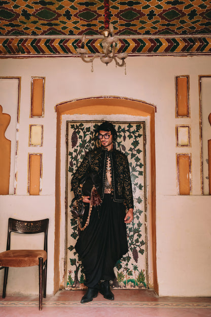 Person in traditional attire standing in a room with decorative walls and ceiling.