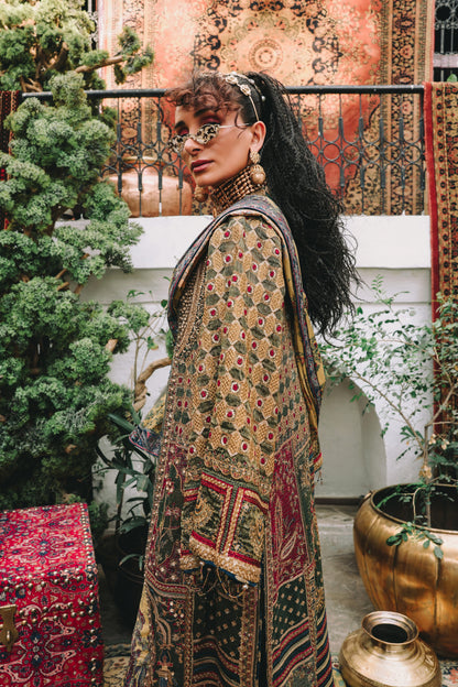 Woman in a patterned outfit standing in an outdoor setting with decorative elements.
