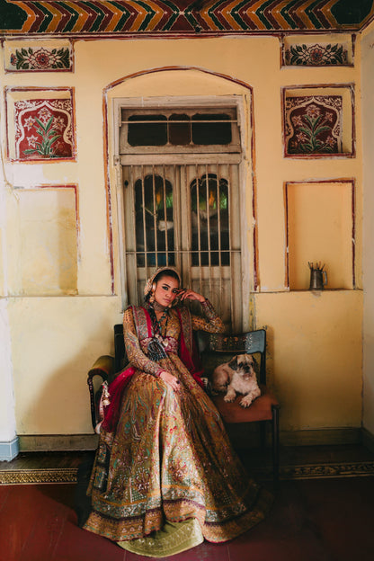 Woman in traditional attire sitting on a chair with a dog in a decorated room.