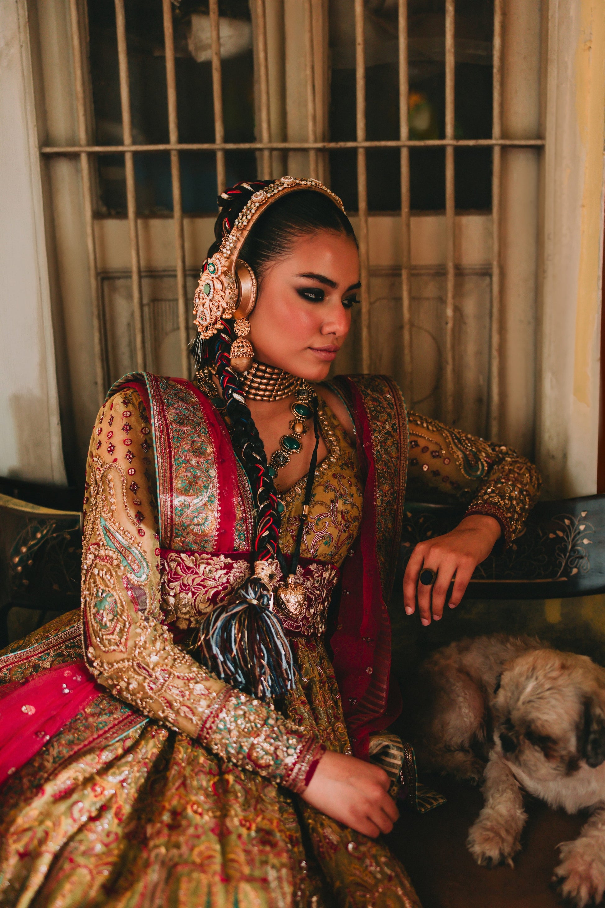 Woman in traditional attire with a dog sitting beside her indoors.