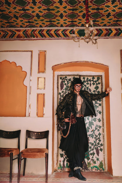 Person in traditional attire standing in a room with ornate walls and ceiling.