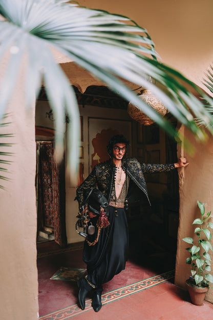 Person in a stylish outfit standing in a doorway with decorative elements and plants.
