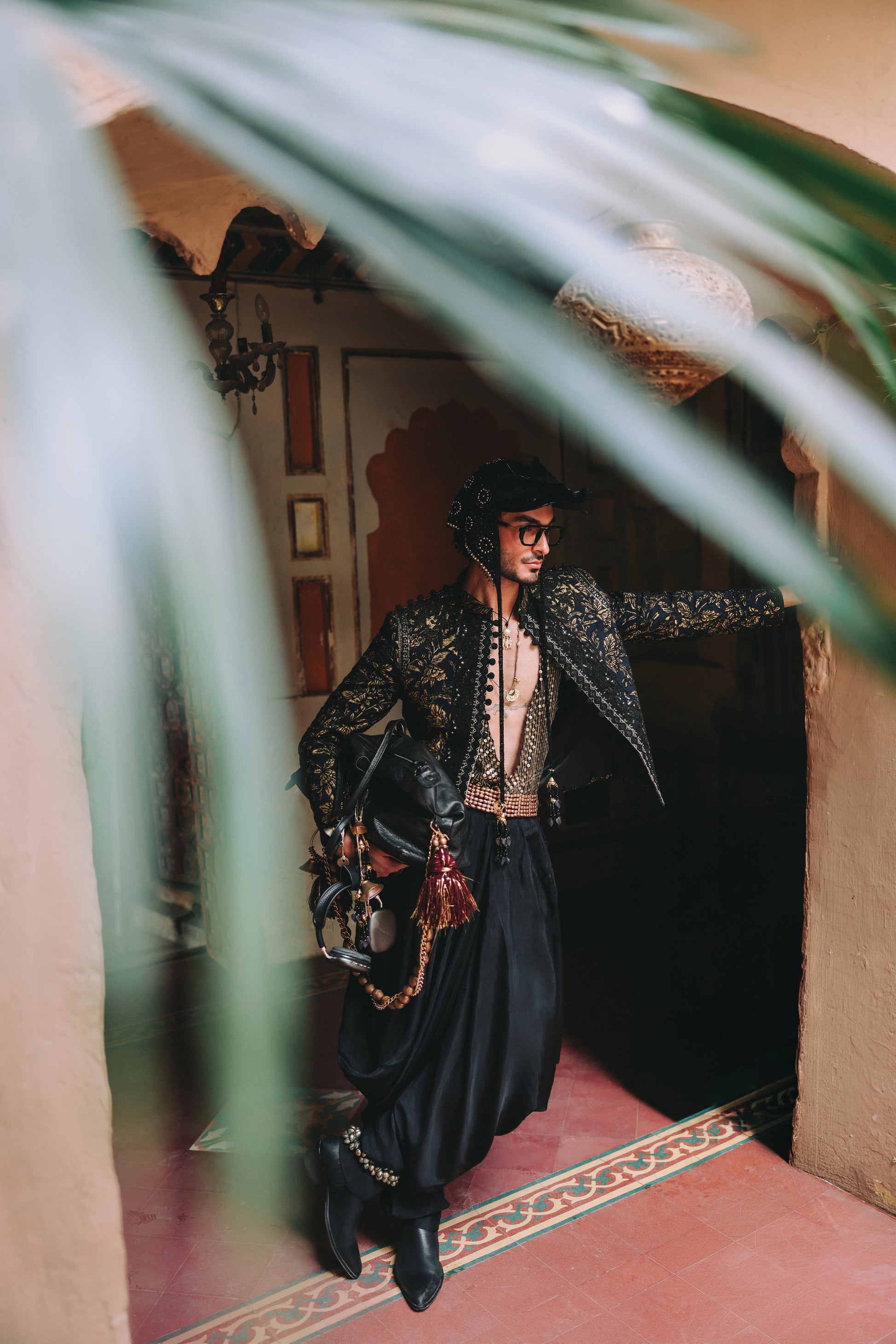 Person in ornate outfit standing in a doorway with decorative elements