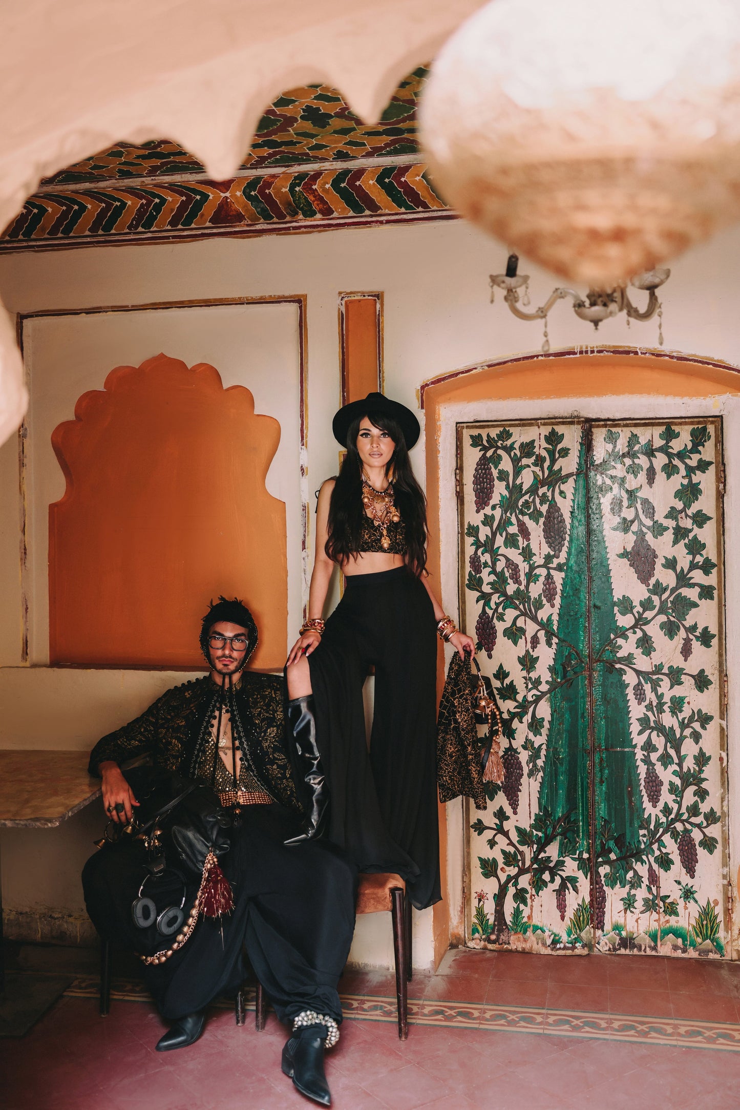 Two people in a room with decorative walls and a mirror.