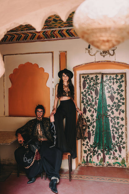 Two people in a room with decorative walls and a mirror.