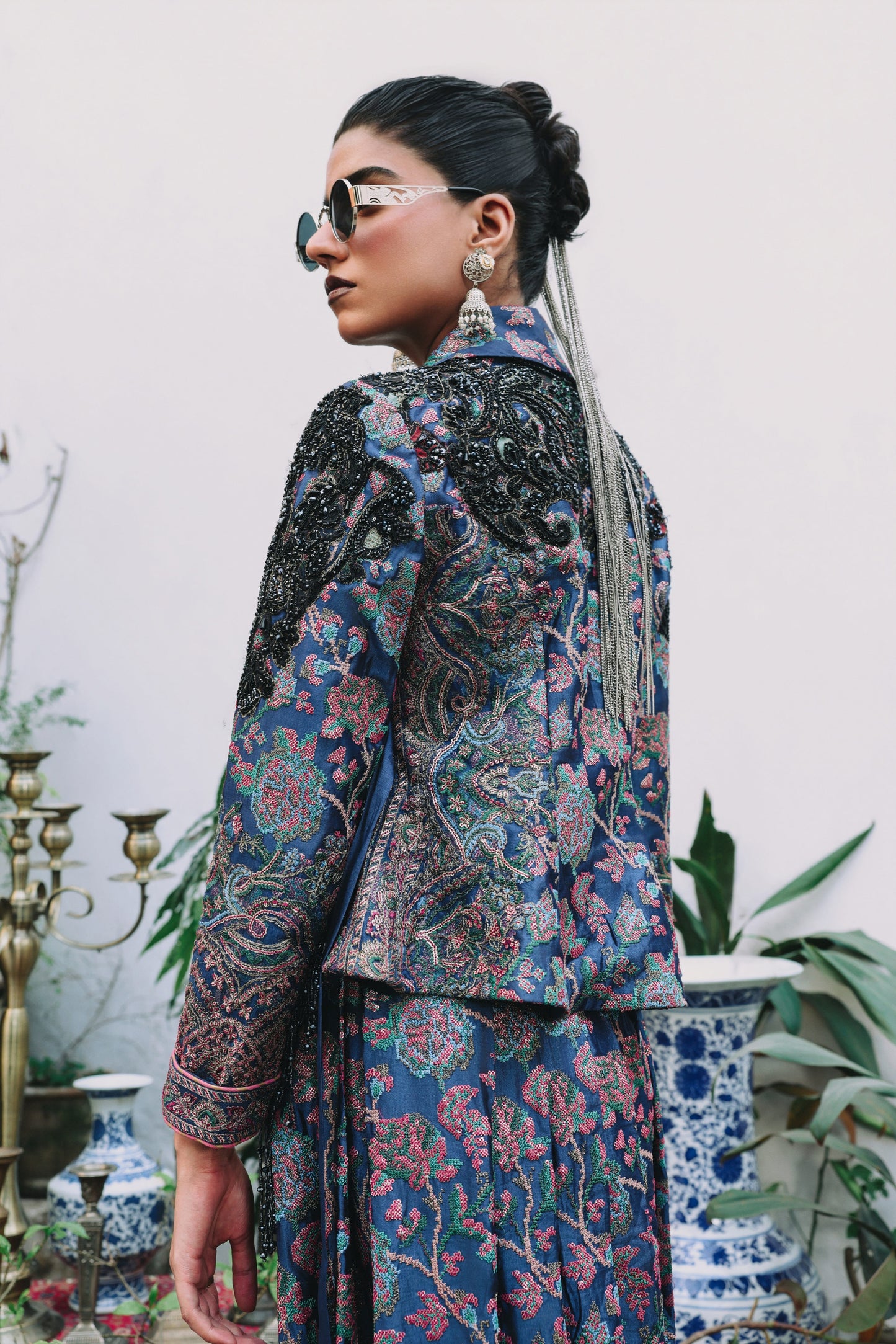 Woman wearing a patterned outfit with sunglasses in an indoor setting
