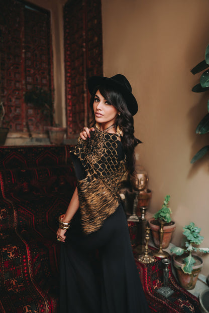 Woman in a stylish outfit with a hat in an interior setting with decorative elements.