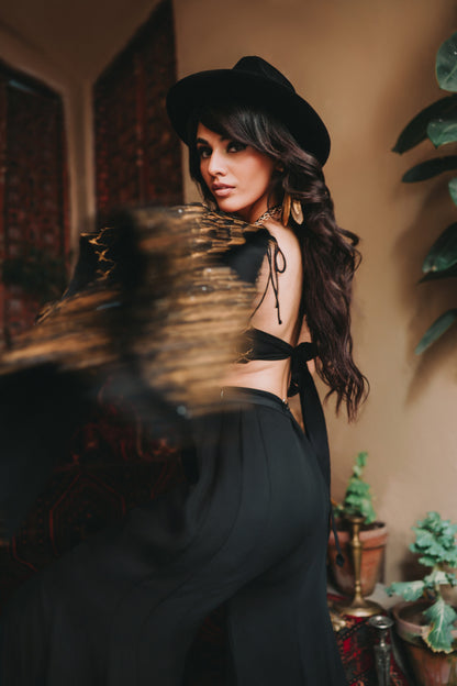 Woman in a black outfit with a hat in an indoor setting