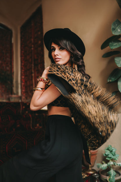 Woman in a stylish outfit with a hat and leopard print coat in an indoor setting.