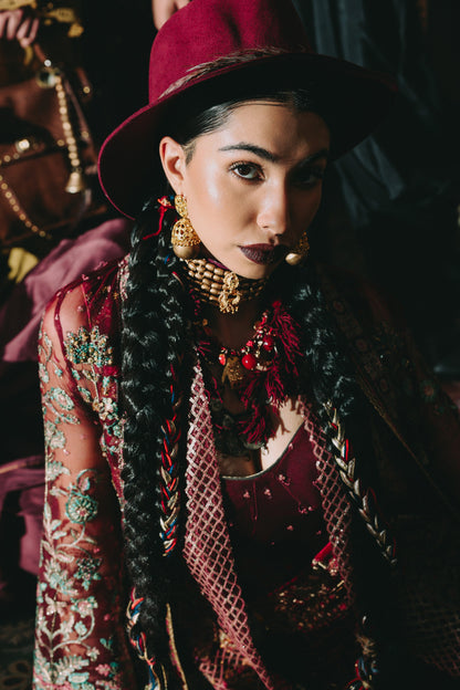 Woman wearing a red hat and traditional outfit with intricate patterns