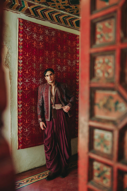 Man in traditional attire standing in a room with ornate decor