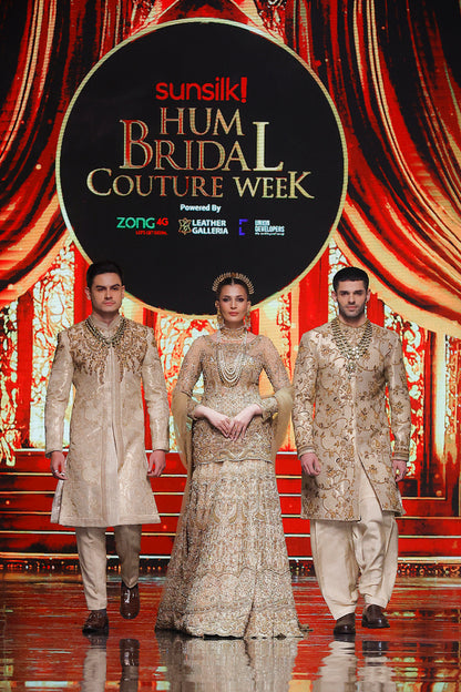 Three models in formal attire on a stage with 'Sunsilk Hum Bridal Couture Week' backdrop.