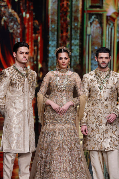 Three individuals in traditional embroidered outfits standing against a colorful, patterned background.