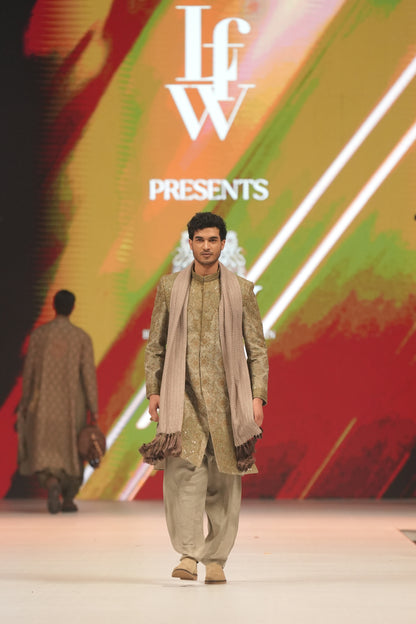 Model walking on a catwalk with a colorful background and 'LFW' branding.