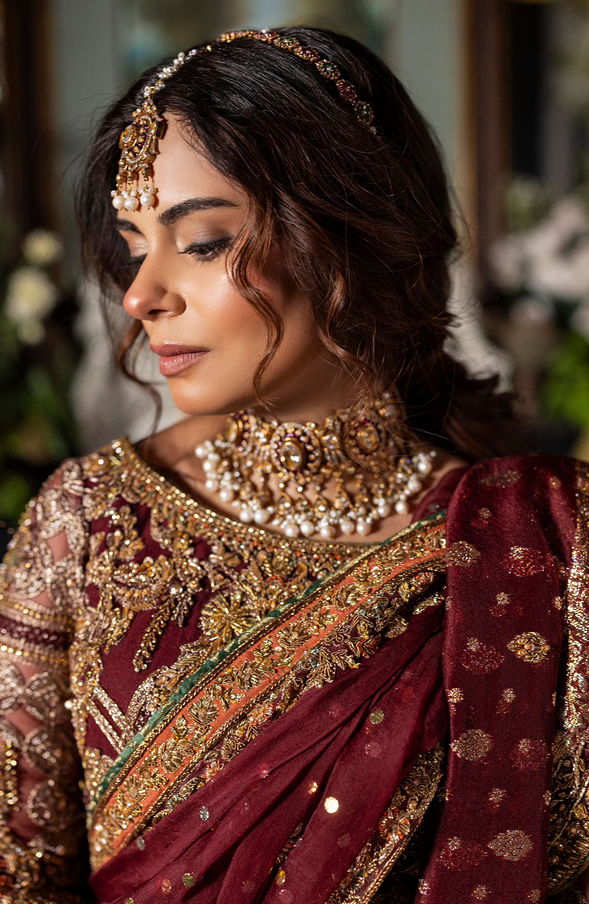 Model wearing maroon choli lehenga set with mukesh dupatta
