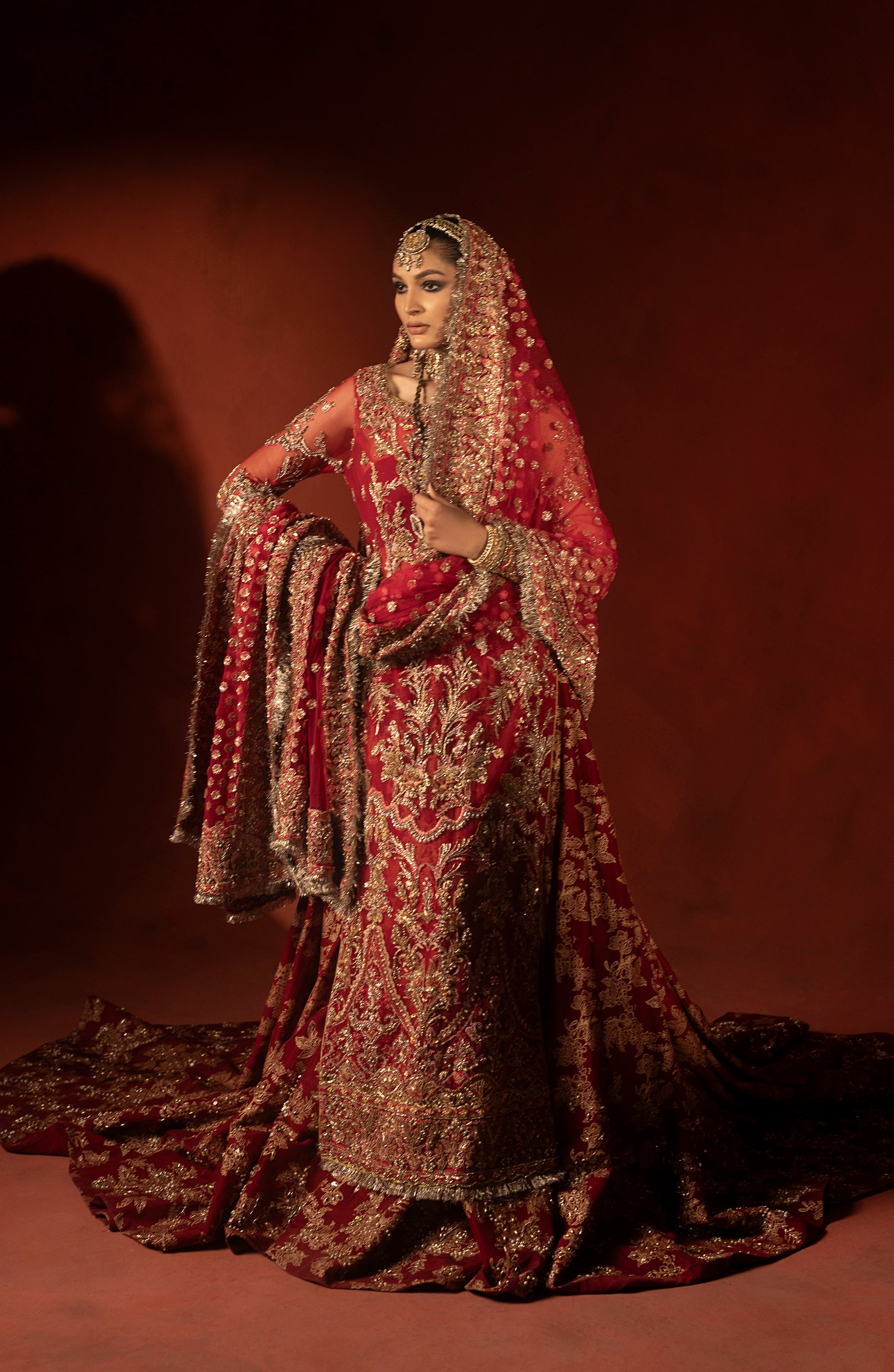 Model showcasing back view of raspberry red wedding lehenga