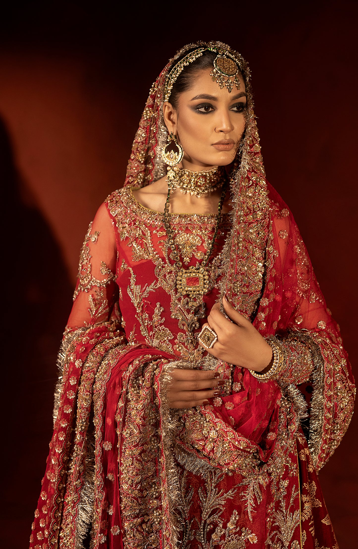 Model wearing raspberry red bridal lehenga set front pose