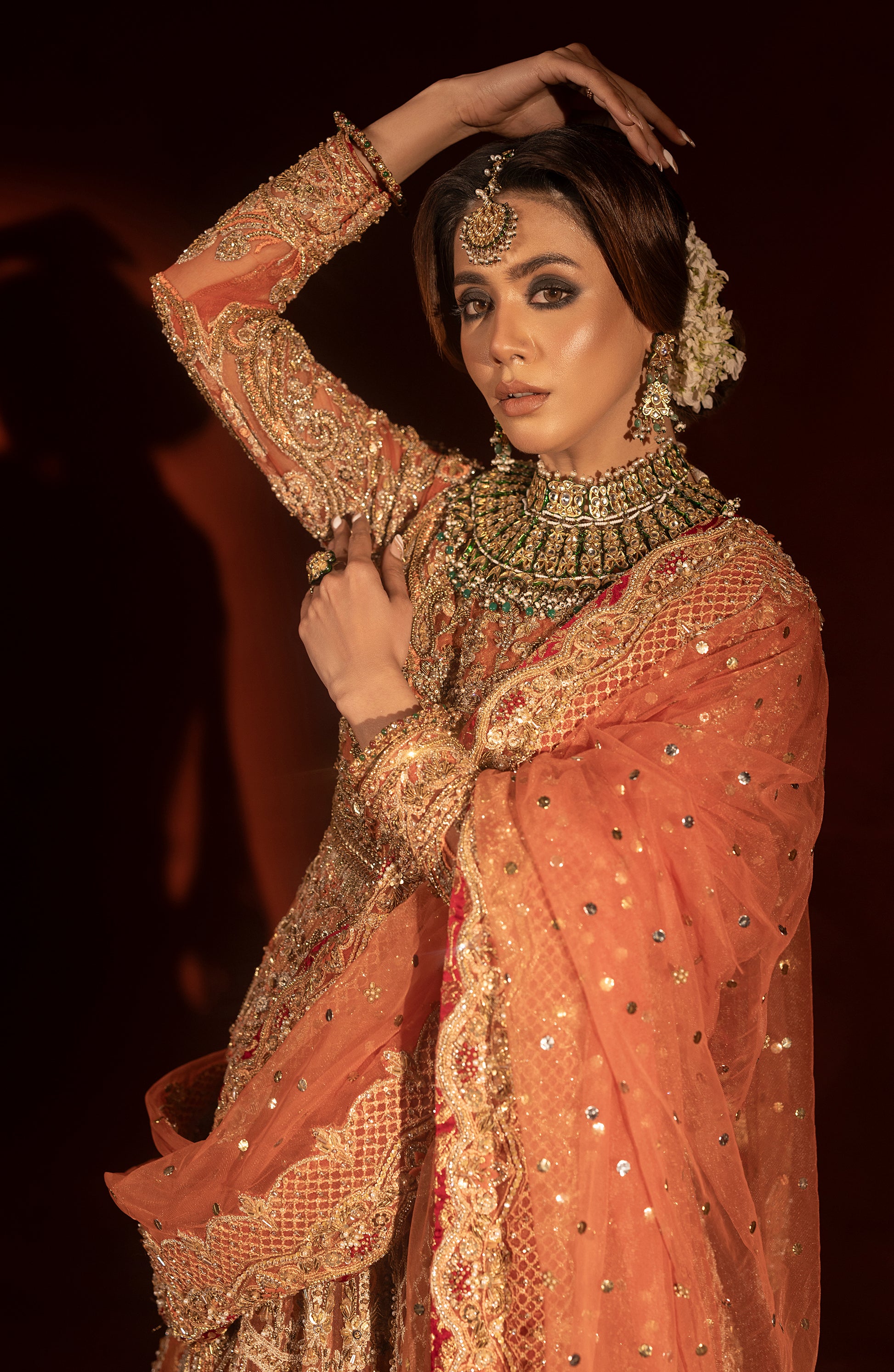 Side profile of rust orange traditional pishwas lehenga outfit