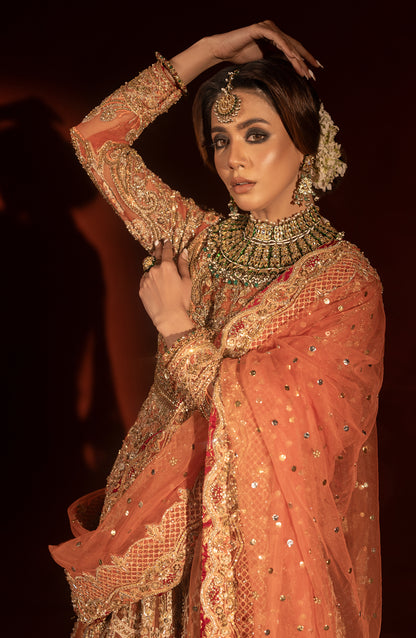 Side profile of rust orange traditional pishwas lehenga outfit