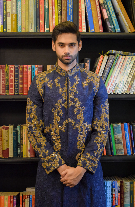Midnight blue sherwani, embellished with oxidised antique gold work. Worn over a matching kurta and pants, made in silk